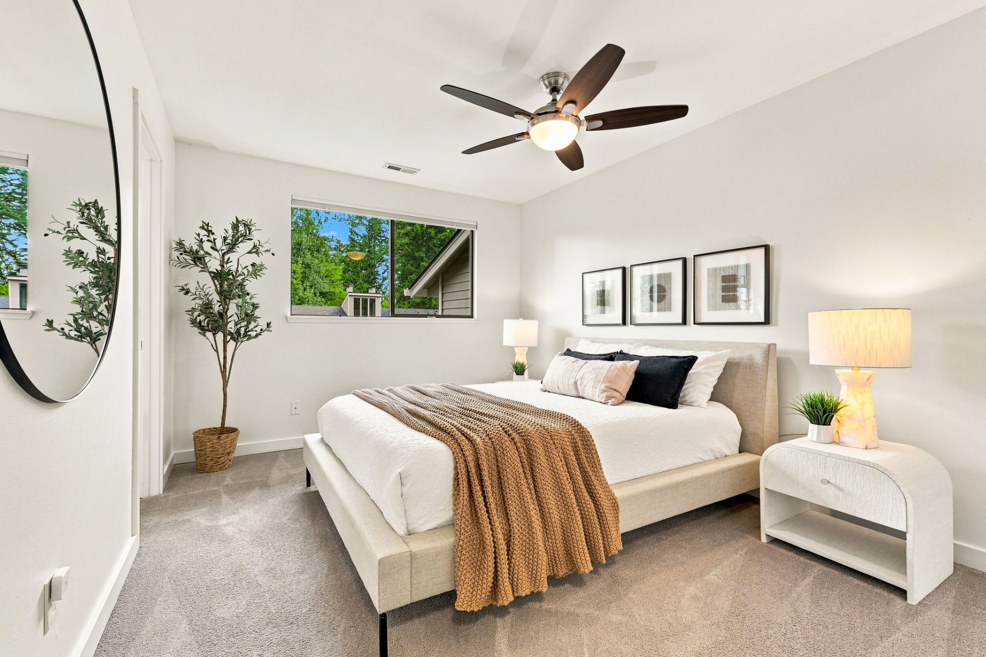 Primary bedroom with natural light and greenery views